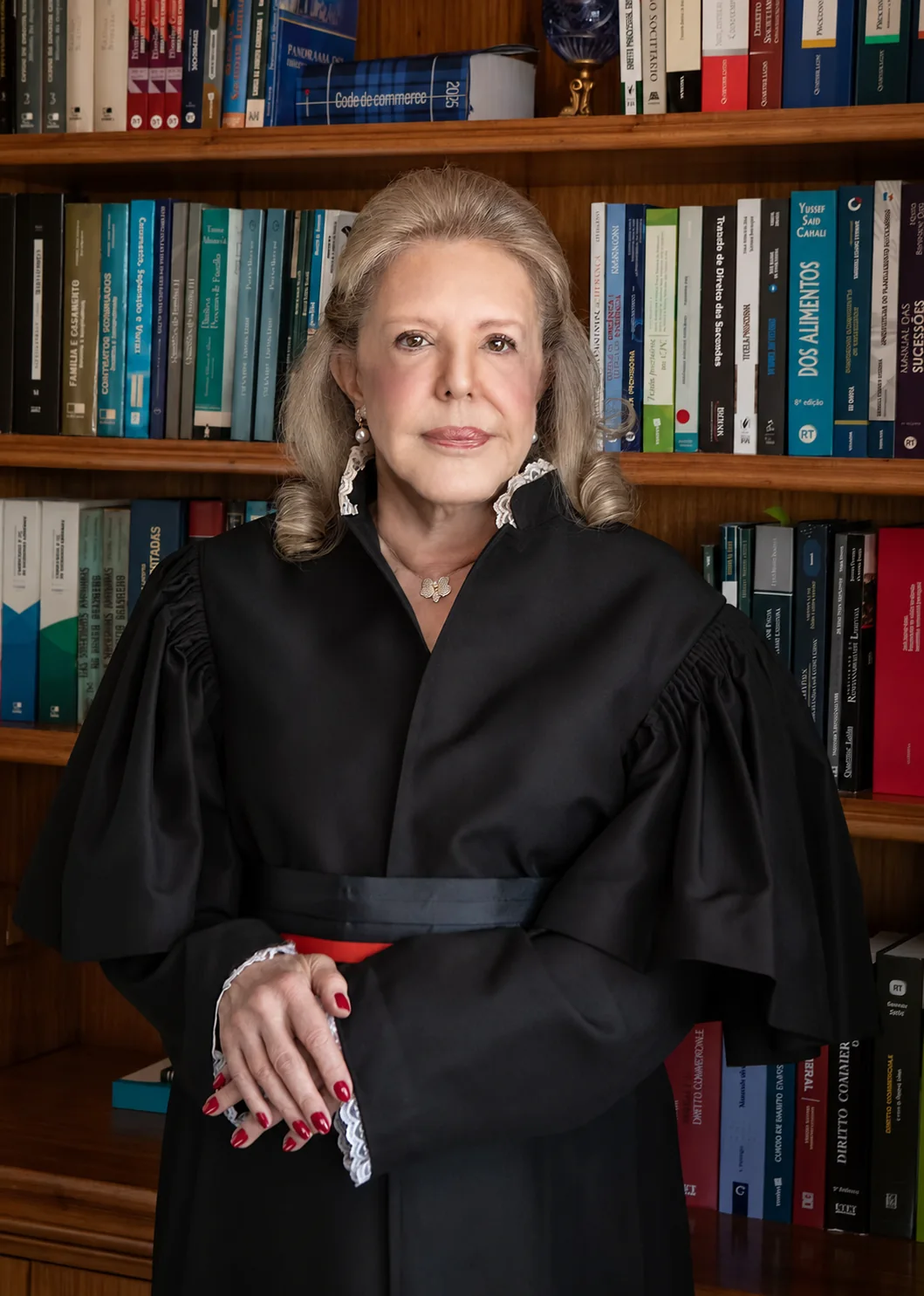 Dra. Priscila M.P. Corrêa da Fonseca diante de biblioteca jurídica.